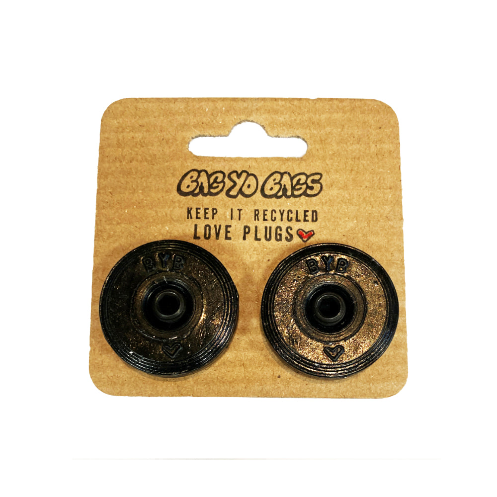 Bag Yo Bags Bar Ends Black Add some eco-friendly flair to your ride with Bag Yo Bags Bar Ends! Made from recycled bags in Québec, these bar ends are not only strong, but also a statement piece for the environmentally conscious rider. Upgrade your mount with a touch of sustainability today!