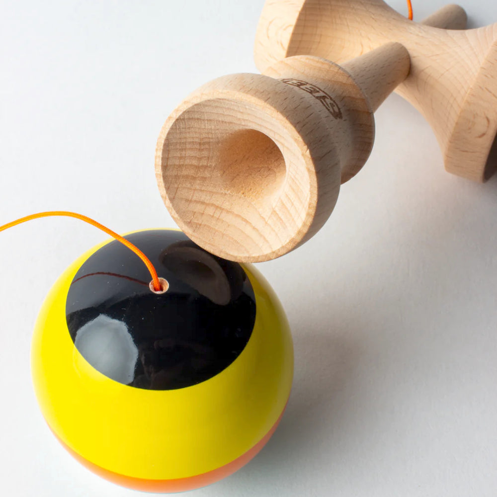 Wooden and yellow Kendama toy on a white background